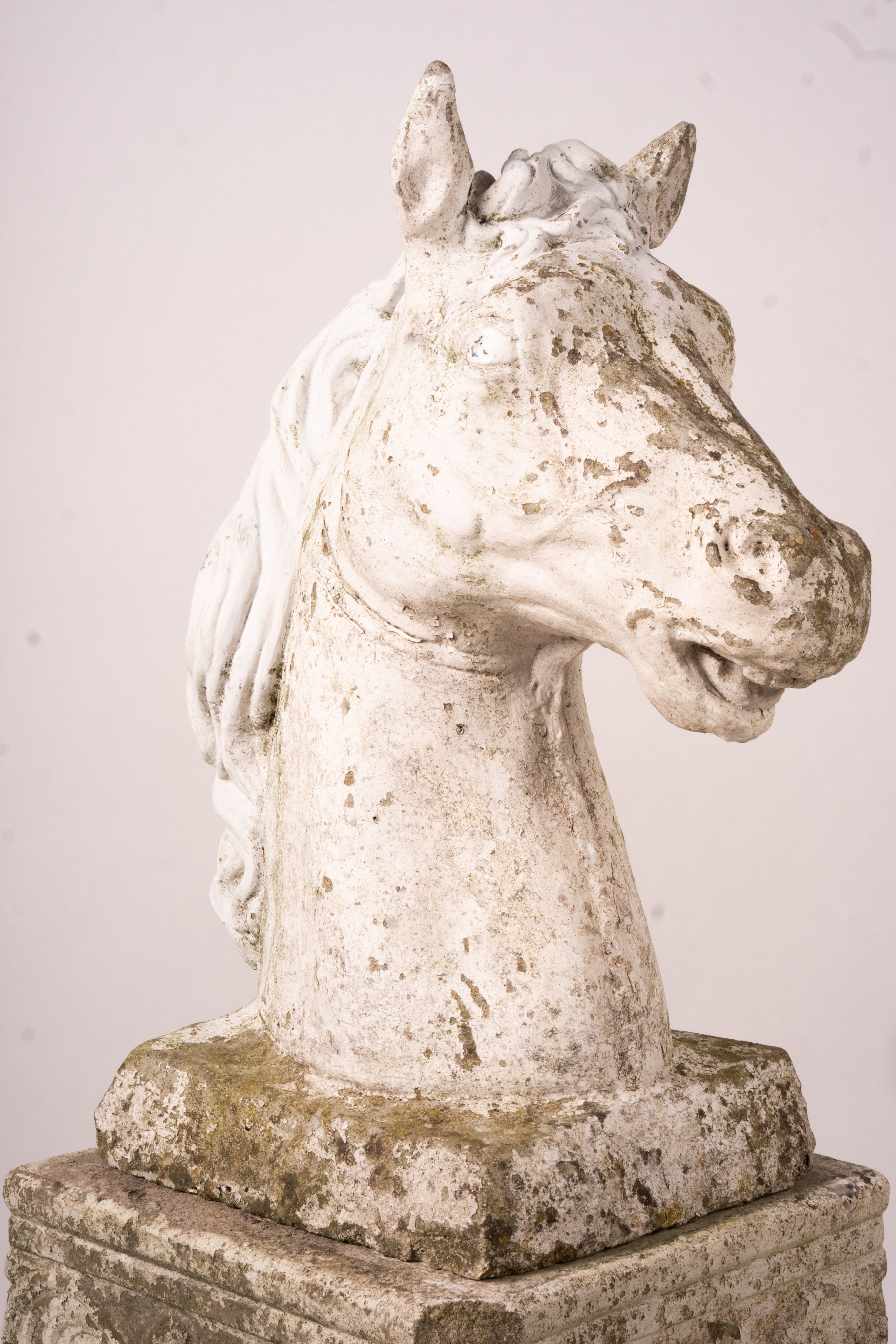 A pair of reconstituted stone horse's heads on plinth bases in the style of Austin and Seeley, height 104cm